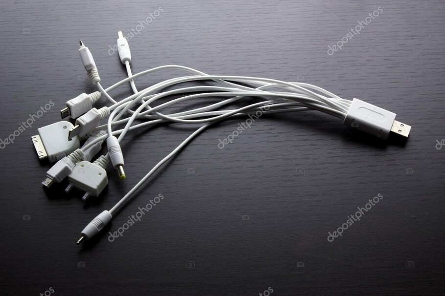 Varie tipologie di cavi e adattatori elettronici su un tavolo