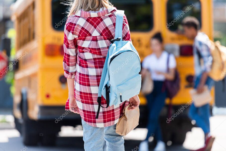 Zaino scolastico appoggiato accanto a libri e quaderni